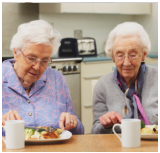 two elderly woman eating